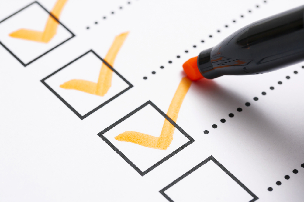 Ein Marker, der die Kontrollkästchen auf einer Checkliste ankreuzt