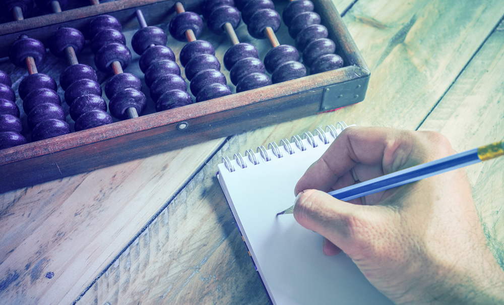 شخص يكتب في دفتر مع العداد في الزاوية