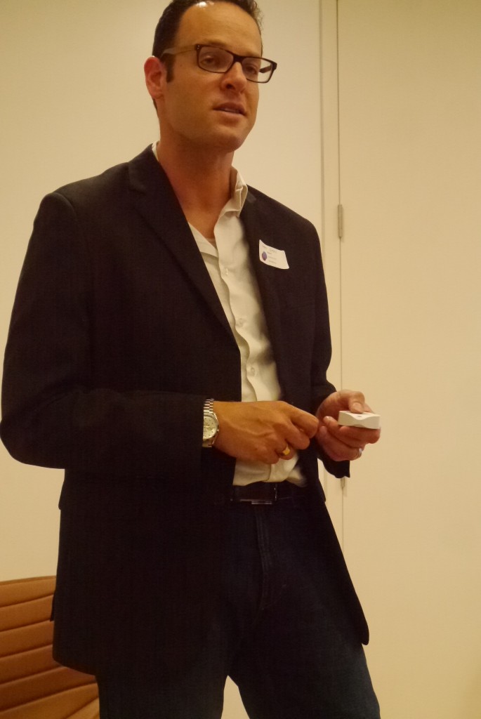 Kwik 首席执行官奥弗·克莱因 (Ofer Klein) 手中拿着一个白色按钮设备的照片。