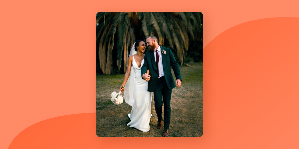 Una foto de una novia y un novio sonriendo mientras caminan de la mano