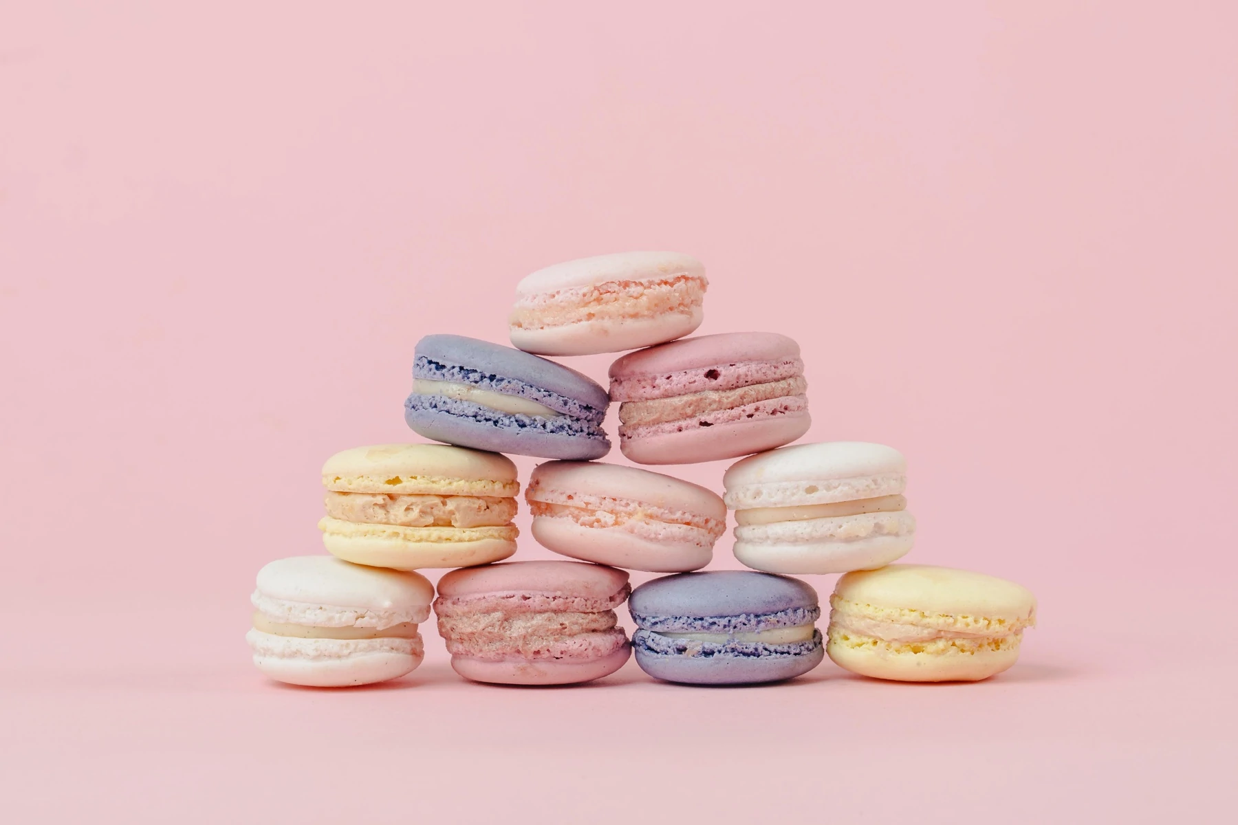 Macarons francesi in colori assortiti su sfondo rosa