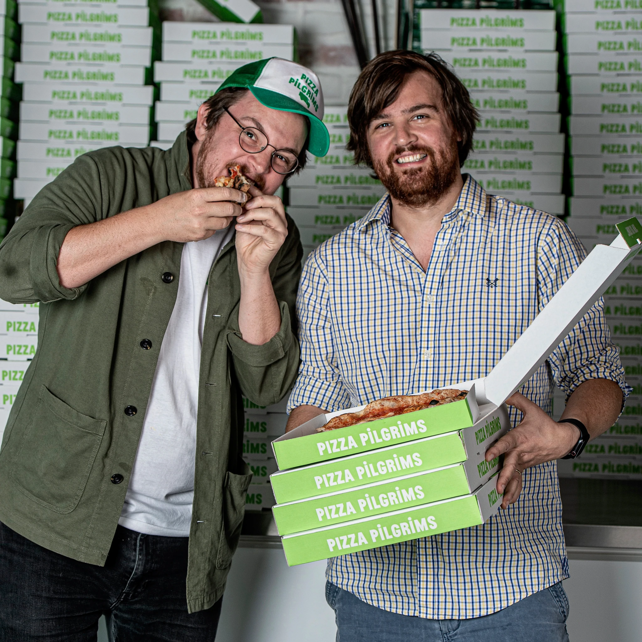 James y Thom Elliot rodeados de innumerables cajas de pizza de Pizza Pilgrims.