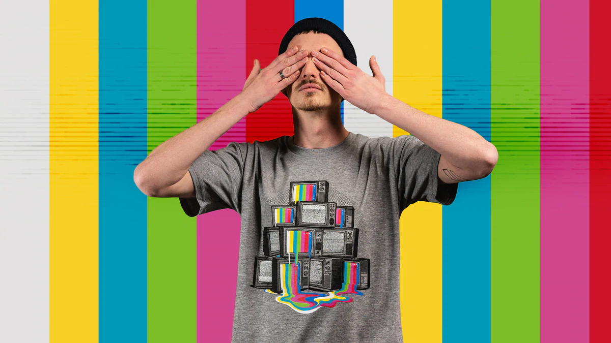 Un modelo masculino con una camiseta con el gráfico de Threadheads y un fondo de rayas de colores.