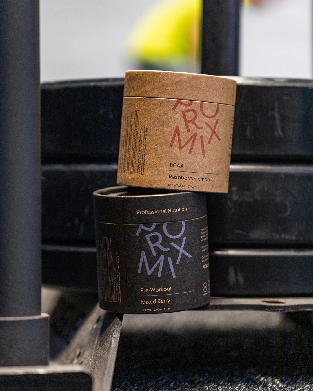 Un par de mezclas de nutrición de Promix con el telón de fondo de un gimnasio.