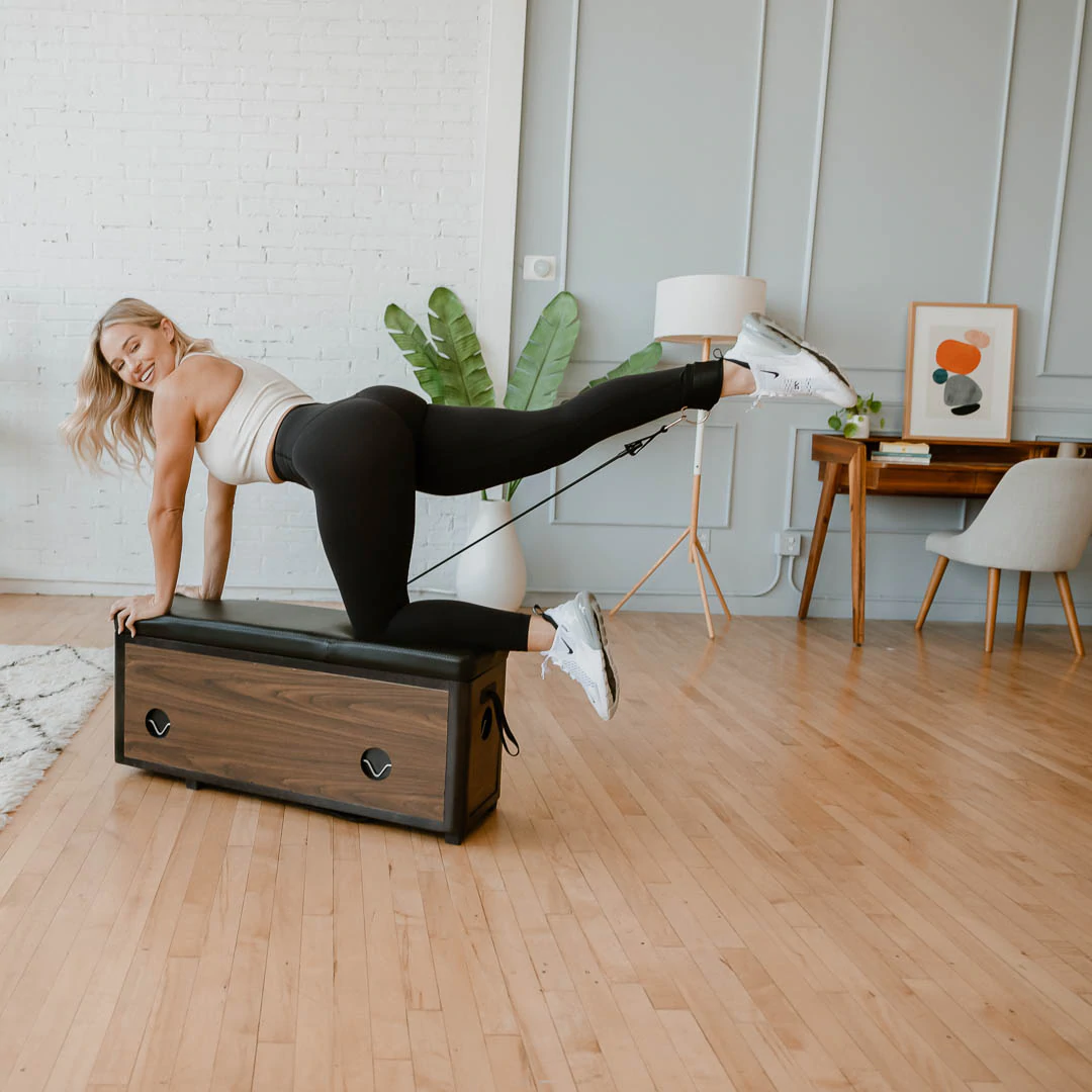 Ein Model verwendet die Trainingsbank Zeno Gym in einer Wohnzimmerumgebung.